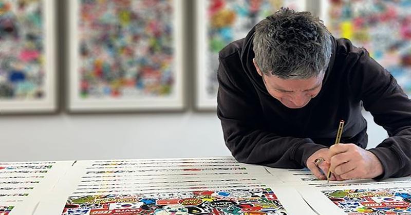 Photo of Noel Gallagher signing donated artwork for Teenage Cancer Trust